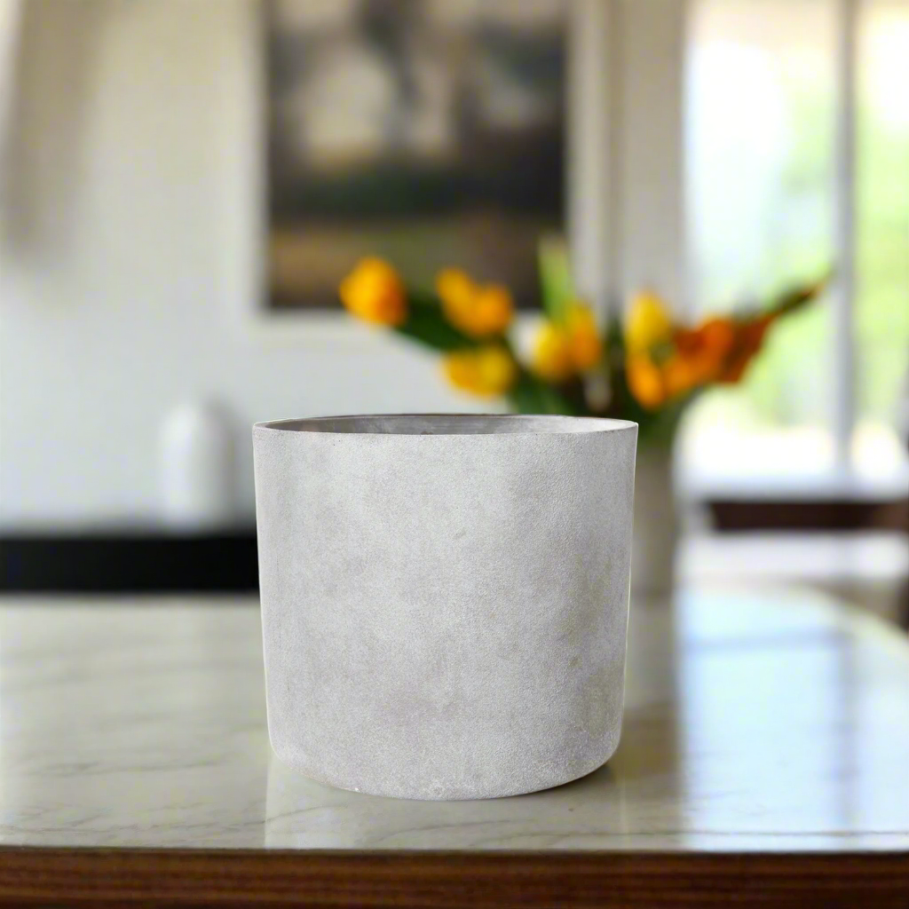 White ceramic planter on a table with a blurred background