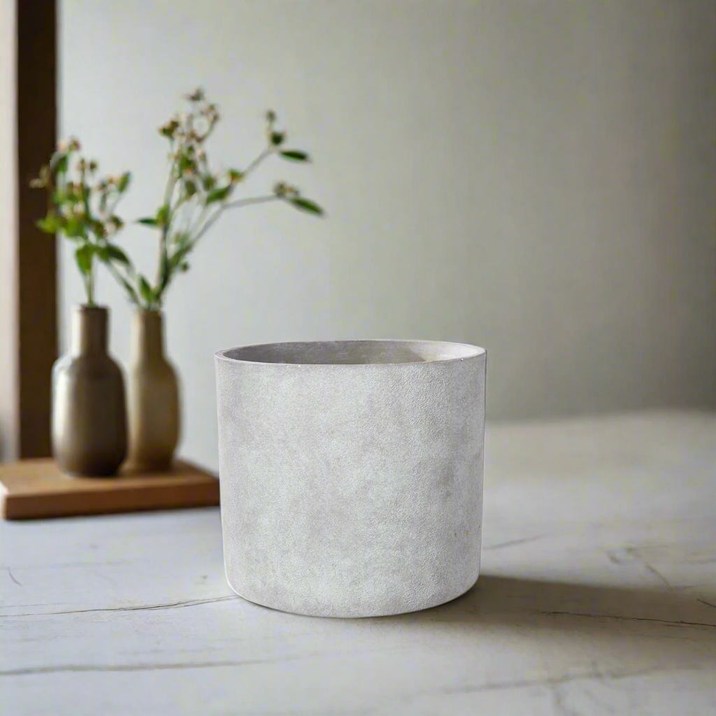 Concrete planter on a light surface with a blurred background