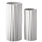 Two white cylindrical vases with ribbed texture on a wooden surface.