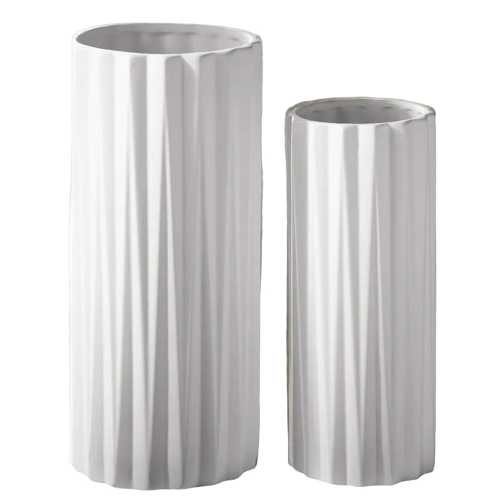 Two white cylindrical vases with ribbed texture on a wooden surface.