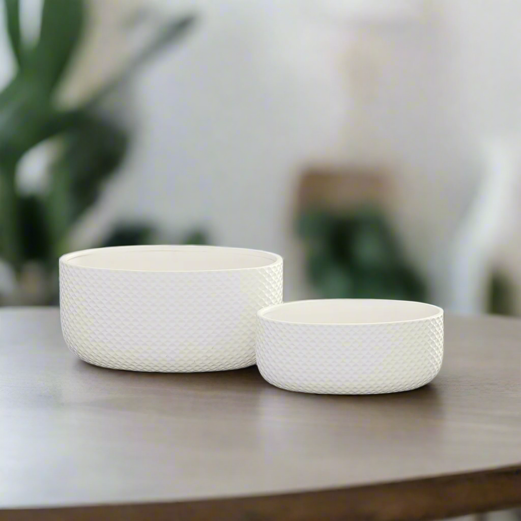 Two white woven baskets on a wooden surface with a blurred background