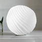 White spherical lamp on a gray surface with a blurred background