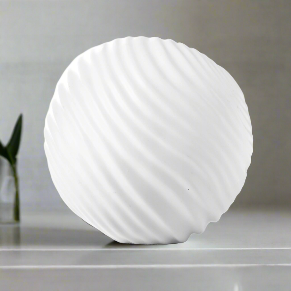 White spherical lamp on a gray surface with a blurred background
