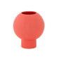 A matte white ceramic round vase with an embossed column and stripe design on the base.