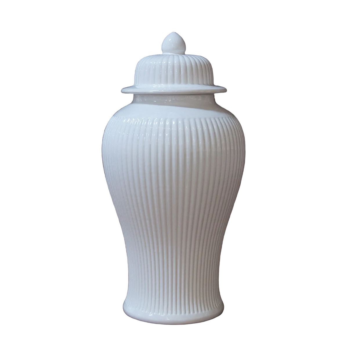 A white ceramic ginger jar with a lid, featuring vertical fluted detailing and a pointed finial on top, set against a plain white background.