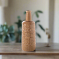 Decorative terracotta vase with intricate patterns on a wooden surface with a blurred indoor background.