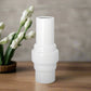 A white ceramic vase with a matte finish.