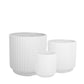 Three white textured planters of different sizes on a white background