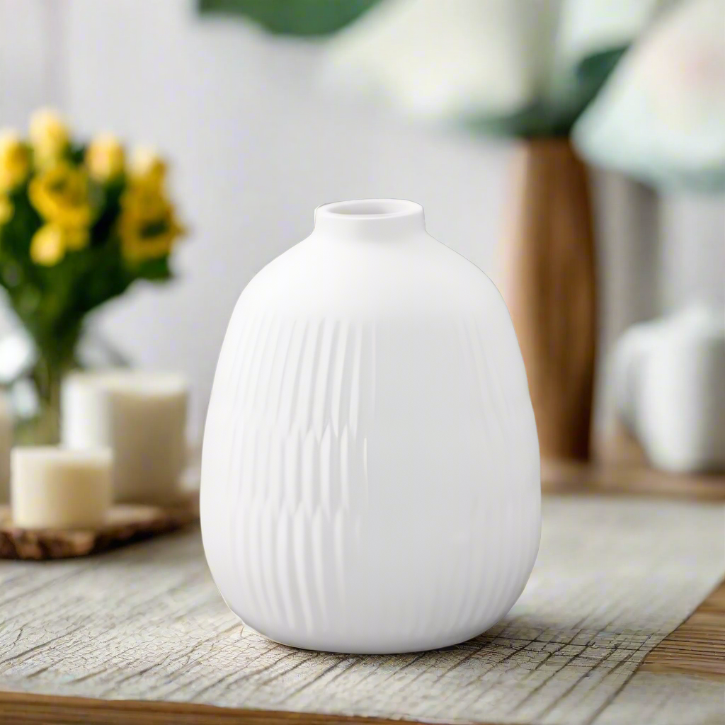 White textured vase on a wooden surface with blurred background