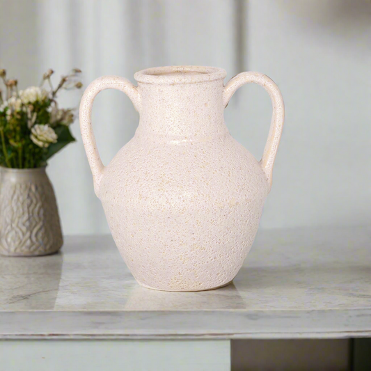 White textured vase on a marble surface with a blurred background