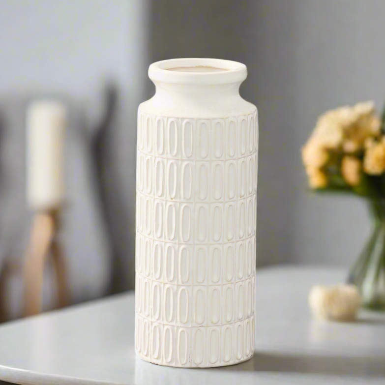 White textured vase on a table with a blurred background