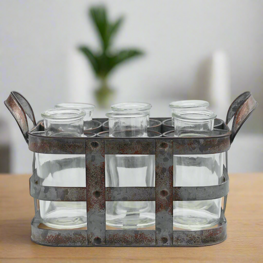 Metal holder with six clear glass jars on a wooden surface