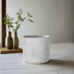 Concrete planter on a light surface with a blurred background